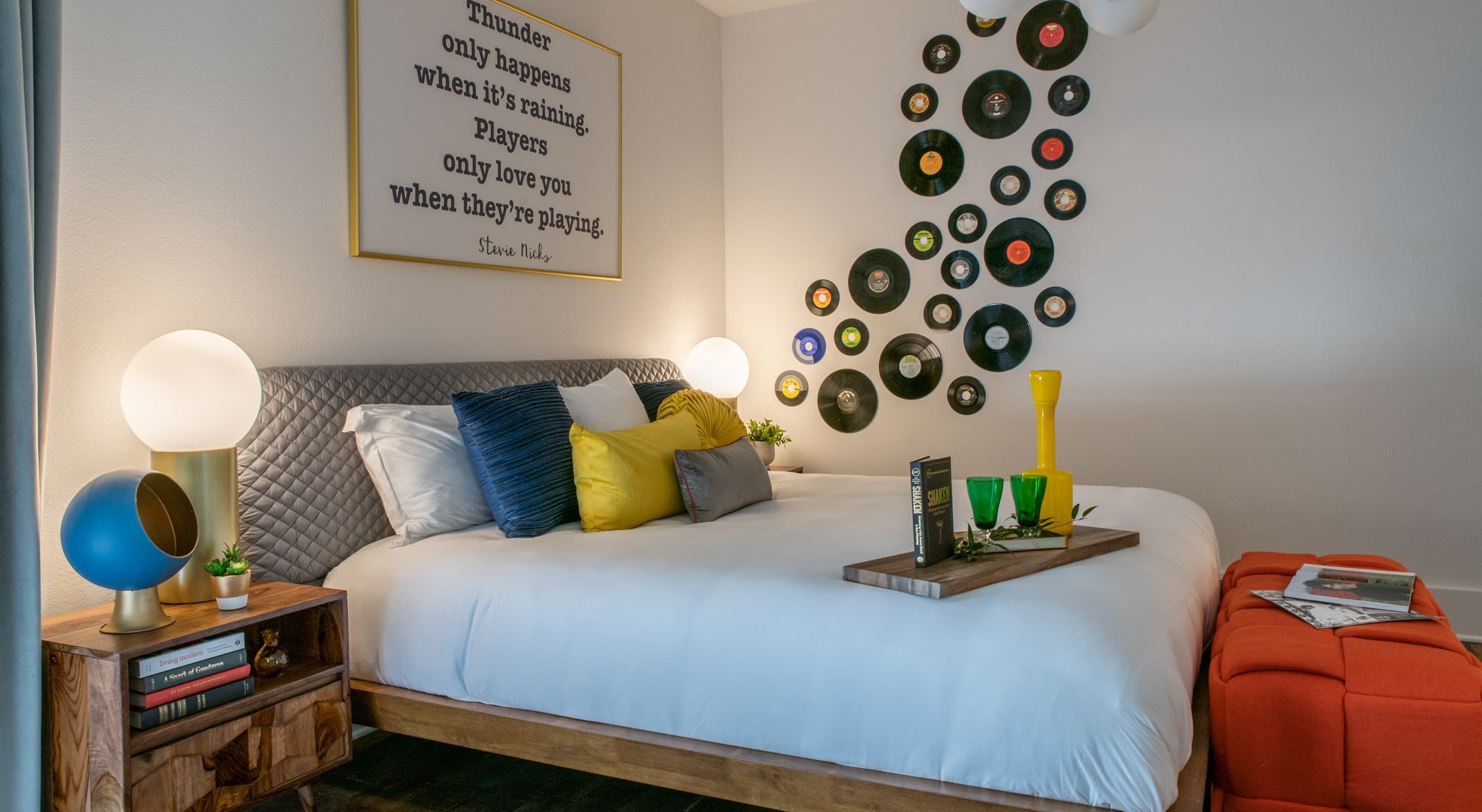 Record theme bedroom with a queen bed and vinyl record art on the wall
