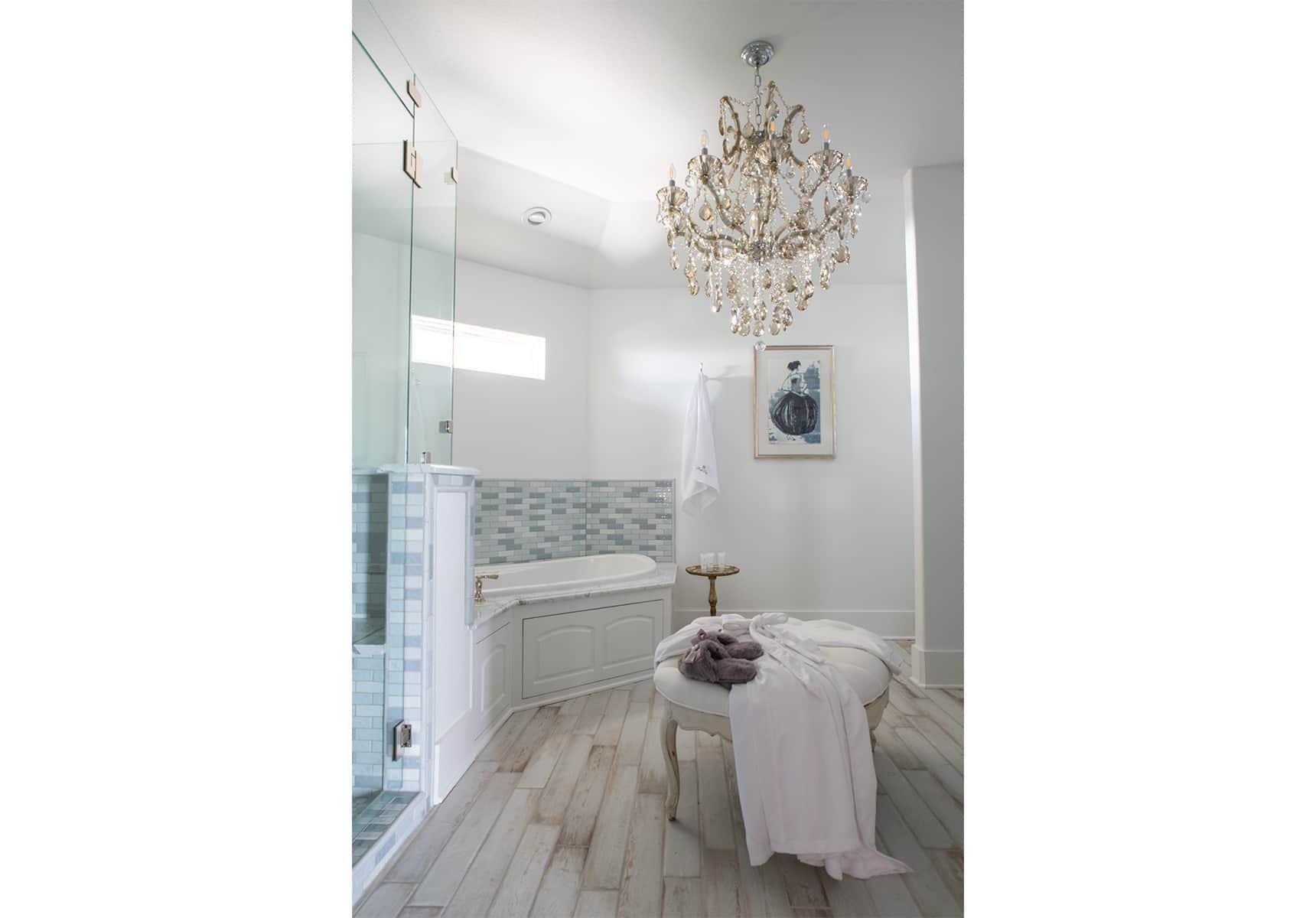 Bathroom with a walk-in shower a tub and a chandelier