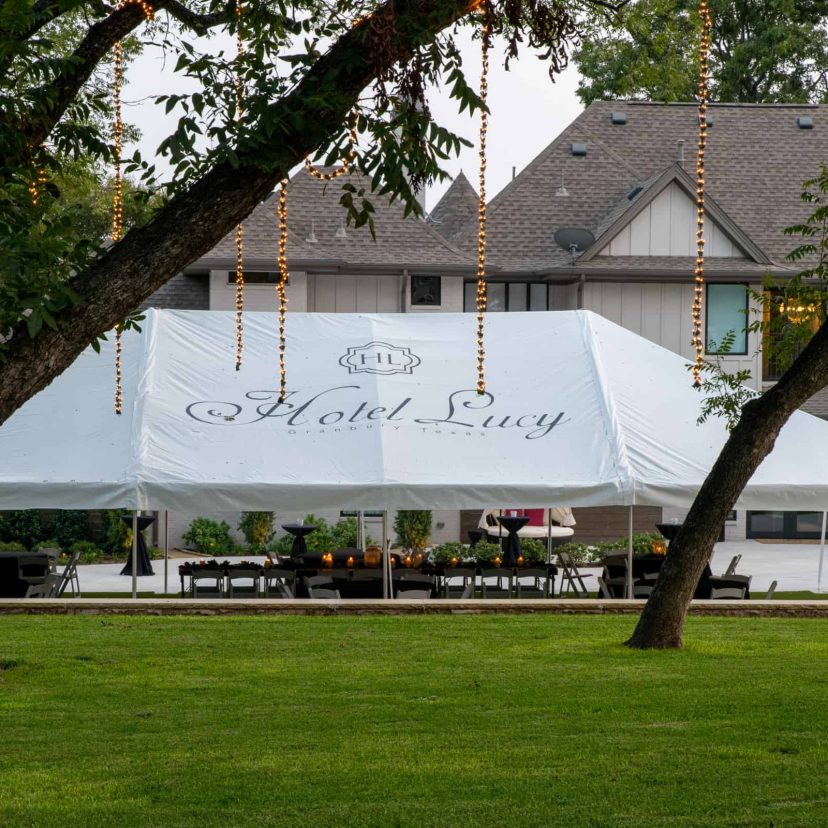 A white event tent with Hotel Lucy on it setup for an event