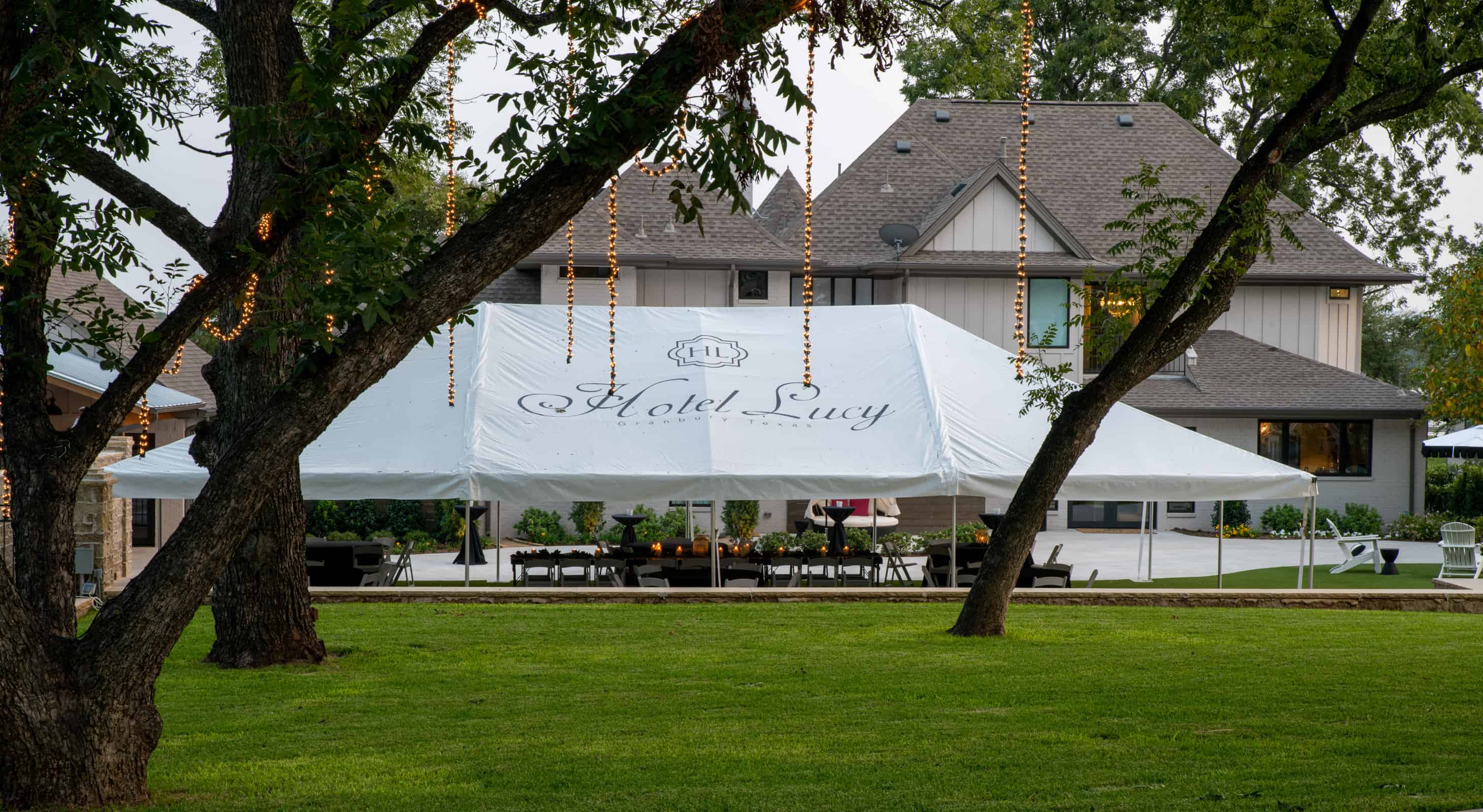 A white event tent with Hotel Lucy on it setup for an event