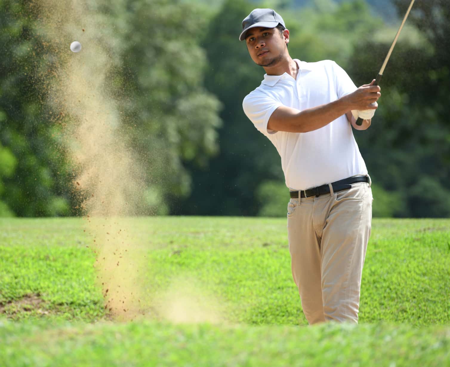 Golfer hitting out of a bunker