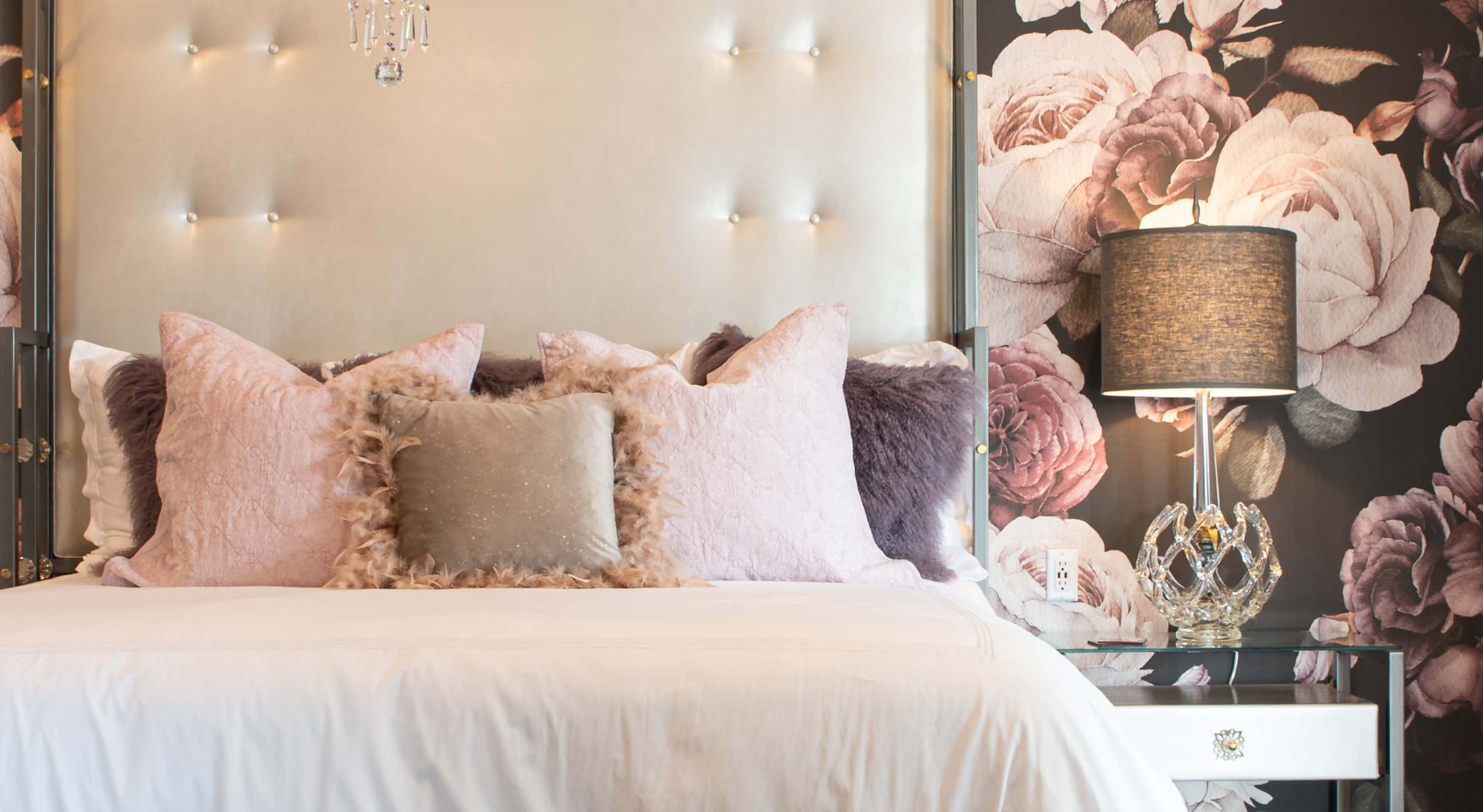 King bed with a glass end table and floral wall paper