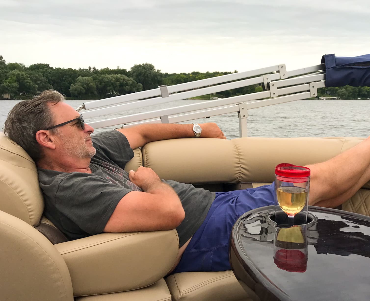 Boomer relaxes on a pontoon boat with a drink